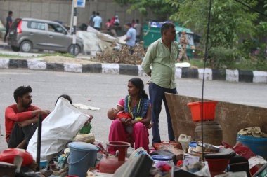 NEW DELHI INDIA HAZİRAN 12023 Aile, Pragati Meydan yakınlarında PWD tarafından 1 Haziran 2023 'te Yeni Delhi' deki Bhairon Marg 'da yürütülen saldırı girişiminin ardından yıkılan derme çatma geçitlerin yanına sığınıyor.