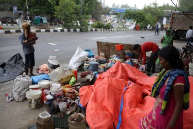 NEW DELHI INDIA HAZİRAN 12023 Aile, Pragati Meydan yakınlarında PWD tarafından 1 Haziran 2023 'te Yeni Delhi' deki Bhairon Marg 'da yürütülen saldırı girişiminin ardından yıkılan derme çatma geçitlerin yanına sığınıyor.