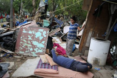 NEW DELHI INDIA HAZİRAN 12023 Aile, Pragati Meydan yakınlarında PWD tarafından 1 Haziran 2023 'te Yeni Delhi' deki Bhairon Marg 'da yürütülen saldırı girişiminin ardından yıkılan derme çatma geçitlerin yanına sığınıyor.