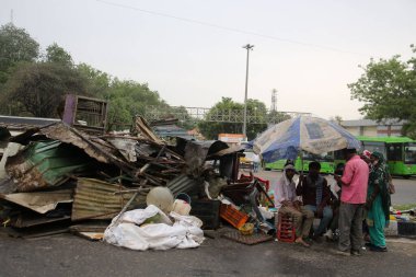 NEW DELHI INDIA HAZİRAN 12023 Aile, Pragati Meydan yakınlarında PWD tarafından 1 Haziran 2023 'te Yeni Delhi' deki Bhairon Marg 'da yürütülen saldırı girişiminin ardından yıkılan derme çatma geçitlerin yanına sığınıyor.