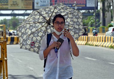 NOIDA INDIA 8 HAZİRAN 2023 sıcak yaz gününde şemsiye altında Noida Hindistan 'da 8 Haziran 2023' te Sunil Ghosh Hindustan Times tarafından çekilmiştir.
