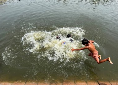 NEW DELHI INDIA 12 Haziran 2023 Çocuklar, 12 Haziran 2023 'te Kalindi Kunj yakınlarındaki sıcak hava dalgaları sırasında Agra drenajı' nda eğleniyorlar. Hindistan, son günlerde ülkenin çeşitli yerlerinde sıcak dalgalarına tanık oluyor. Fotoğraf: Salman Al