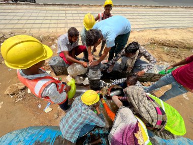 NEW DELHI INDIA 12 Haziran 2023 Öğlen saatlerinde Pragati Meydan yakınlarında güneşli bir günde öğle yemeğinde su şişelerini dolduran uzun kuyruktaki işçiler Yeni Delhi 'de Hindistan, ülkenin çeşitli bölgelerinde sıcak dalgalarına tanık oluyor.