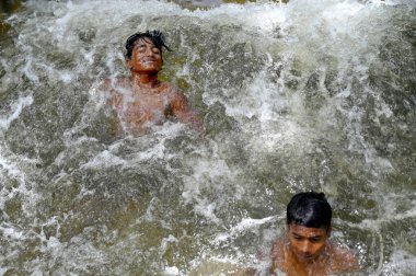 NOIDA INDIA 12 HAZİRAN 2023 Çocuklar kavurucu sıcaktan dinlenmek isterken kendilerini 54. bölgedeki kanalizasyon arıtma tesisinden akan suda banyo yaparken buldular.