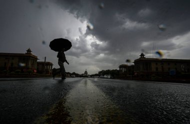 YENİ DELHI INDIA 16 HAZİRAN 2023 Bir adam, yağmurlu bir günde Vijay Chowk 'un üzerinde kara bulutların altında yürür Yeni Delhi' de 16 Haziran 2023 Hindistan Meteoroloji Bölümü, Perşembe günü Delhi NCR 'de şiddetli rüzgarlarla hafif yağmur öngörmüştü.