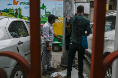 NEW DELHI INDIA JUNE 26 2023 Workers Repairing the an open electric circuit breaker box or a breaker box at New Delhi Railway station parking Area on June 26 2023 in New Delhi India A 35 year old woman who stepped onto a flooded street at the New Del clipart