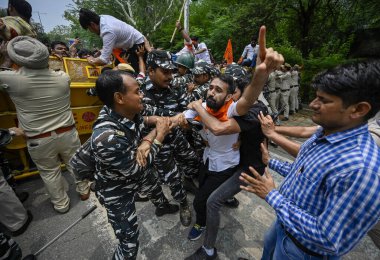 YENİ DELHI INDIA JUNE 27 Haziran 2023 Delhi Polisi ve paramiliter personeli, Delhi Başbakanı Arvind Kejriwal 'ın yetkisiz c' ye karşı düzenlenen protesto sırasında Akhil Bharatiya Vidyarthi Parishad ABVP Öğrenci Birliği üyesini gözaltına aldı