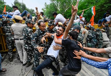 YENİ DELHI INDIA JUNE 27 Haziran 2023 Delhi Polisi ve paramiliter personeli, Delhi Başbakanı Arvind Kejriwal 'ın yetkisiz c' ye karşı düzenlenen protesto sırasında Akhil Bharatiya Vidyarthi Parishad ABVP Öğrenci Birliği üyesini gözaltına aldı