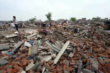 NEW DELHI INDIA MAY 2 2023 Locals seen taking out their valuables from the demolished structures as ASI along with the district administration carries out demolishing drive of illegal constructions near Tughlaqabad Fort on May 2 2023 in New Delhi Ind clipart