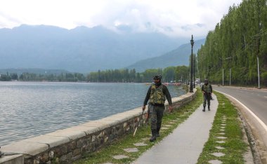 SRINAGAR, INDIA, 4 Mayıs 2023: Paramiliter asker, Srinagar Hindistan 'da 4 Mayıs 2023' te Dal Gölü kıyılarını metal dedektörüyle kontrol ediyor. 22-24 Mayıs tarihleri arasında Srinagar 'da G20 ülkelerinden delegeler toplantısı düzenlenecek.. 