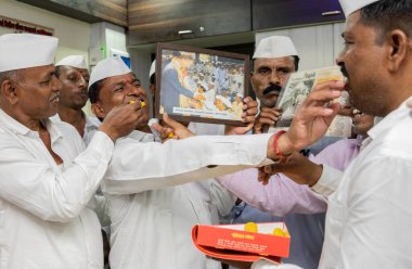 MUMBAI INDIA 6 Mayıs 2023 Mumbai dabbawalas kutlamalarında Prens Charles 'ın Westminster Manastırı' nda düzenlenen taç giyme töreninde İngiltere 'nin 40. hükümdarı olarak taç giymesi üzerine birbirlerine tatlı yedirdiler.