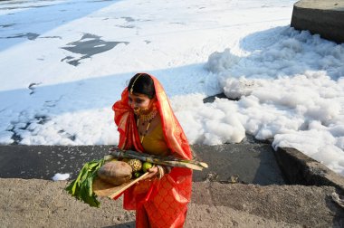 YENİ DELHI INDIA 29 Ekim 2024 Bir kadın sanatçı sosyal medya için bir makara yapar Kalindi Kunj Ghat 'ta Chhas Puja' dan önce beyaz köpük arasında su yüzeyinde yüzen 29 Ekim 2024 Yeni Delhi Hindistan 'da keskin köpük yüksek düzeyde amonyak içerir