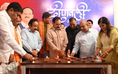 NEW DELHI INDIA OCTOBER 30 2024 BJP Vice President and Delhi Incharge Baijayant Jay Panda and Delhi BJP president Virendra Sachdeva along with MPs and party leaders light the lamp celebrating Diwali Festival during the diwali Milan programme at Delhi clipart