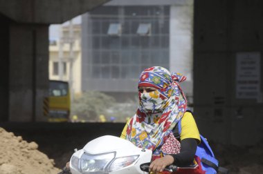 GURUGRAM INDIA MAY 15 2023 A girl going on a scooty motorbike wearing a scarf on face for sunlight hot weather protection at sector 102 near Daultabad village on May 15 2023 in Gurugram India Photo by Parveen Kumar Hindustan Times clipart