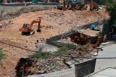 NEW DELHI INDIA MAY 20 2023 A portion of road caved during the excavation work near under construction Maidan Garhi metro station in South Delhi road has sunk around 50 feet deep on May 20 2023 in New Delhi India No injuries have been reported in the clipart