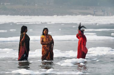 NOIDA INDIA NOVEMBER 5. 2024 Dindarlar, Chhas Puja 'nın 5 Kasım 2024 tarihinde Noida Hindistan' daki ilk gününde kirli Yamuna Nehri 'nde Puja' yı sahneleyecekler.
