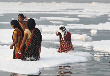 NOIDA INDIA NOVEMBER 5. 2024 Dindarlar, Chhas Puja 'nın 5 Kasım 2024 tarihinde Noida Hindistan' daki ilk gününde kirli Yamuna Nehri 'nde Puja' yı sahneleyecekler.