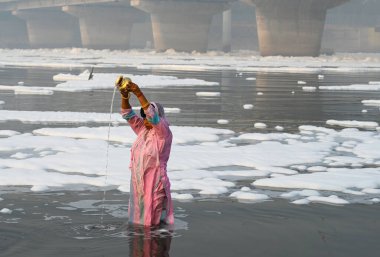 NOIDA INDIA NOVEMBER 5. 2024 Dindarlar, Chhas Puja 'nın 5 Kasım 2024 tarihinde Noida Hindistan' daki ilk gününde kirli Yamuna Nehri 'nde Puja' yı sahneleyecekler.