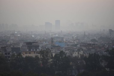 GURUGRAM, INDIA - 8 Aralık 2024: Hindistan 'ın Gurugram kentinde 8 Aralık 2024 tarihinde, Rajiv Chowk Gate yakınlarında, yoğun bir sis ve sisli sabah katmanına gömüldü. Delhi 'nin asgari sıcaklığı 7C civarında seyrediyor. 