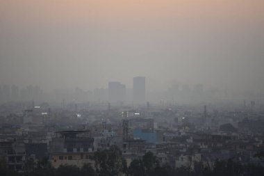 GURUGRAM, INDIA - 8 Aralık 2024: Hindistan 'ın Gurugram kentinde 8 Aralık 2024 tarihinde, Rajiv Chowk Gate yakınlarında, yoğun bir sis ve sisli sabah katmanına gömüldü. Delhi 'nin asgari sıcaklığı 7C civarında seyrediyor. 