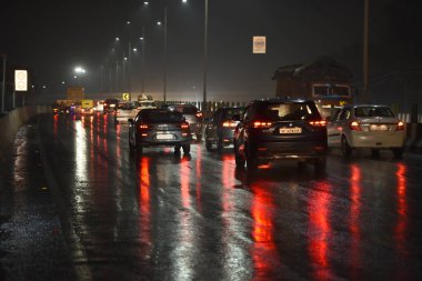 GHAZIABAD, INDIA - 8 ARALIK 2024: 19.30 sularında hafif yağmur yağışı oldu, yollar ıslandı. Ulusal Otoyol 9 Dasna, 8 Aralık 2024 tarihinde Hindistan 'ın Gaziabad kentinde. Pazar günü Delhi-NCR 'nin bazı bölgelerinde şiddetli yağış yaşandı. 