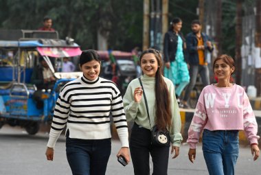 NOIDA, INDIA - 8 Aralık 2024 Noida, Hindistan 'da soğuk ve hafif sisli bir sabah, sıcak giysiler içinde banliyö dışarı çıktı. Delhi 'nin asgari sıcaklığı 7C civarında seyrediyor. 