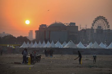 GURUGRAM, INDIA - 8 Aralık 2024: Çekirge oynayan gençler yoğun sis tabakasının ortasında 8 Aralık 2024 'te Hindistan' ın Gurugram kentinde Leisure Valley Park yakınlarındaki 29. Delhi 'nin asgari sıcaklığı 7C civarında seyrediyor. 