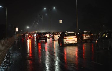 GHAZIABAD, INDIA - DECEMBER 8, 2024: There was light drizzle at around 7:30 pm, due to which the roads became wet. National Highway 9 Dasna , on December 8, 2024 in Ghaziabad, India. Several parts of Delhi-NCR experienced heavy rainfall on Sunday.  clipart