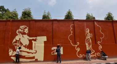 NEW DELHI INDIA APRIL 1 2023 Artists paint the wall of Delhi Universitys Indraprastha College for Women at Civil Lines on April 1 2023 in New Delhi India  clipart