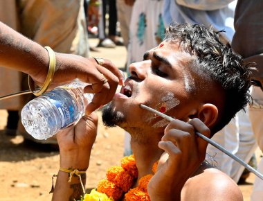 MUMBAI, INDIA: 5 Nisan 2023 - Doğu Aarey Goregaon Kolonisi 'nde Lord Murugan' a adanmış Panguni Uthiram festivali kutlamaları vesilesiyle dini tören sırasında ağızlarına metal şiş sokan Tamil hayranları.