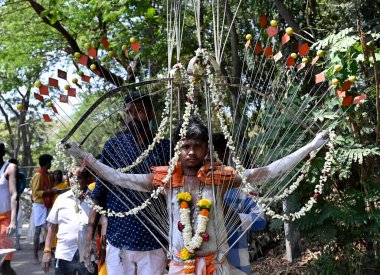 MUMBAI, INDIA: APRIL 5, 2023 - Tamil devotees with metal skewer pierced through their mouths during a religious procession on the occasion of Panguni Uthiram festival celebrations specially devoted to Lord Murugan at Aarey Colony Goregaon East. clipart