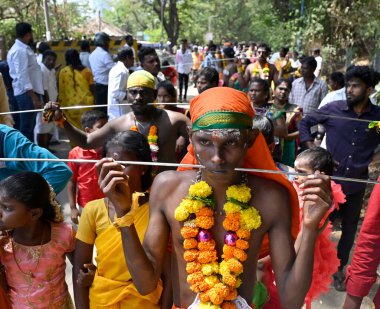 MUMBAI, INDIA: APRIL 5, 2023 - Tamil devotees with metal skewer pierced through their mouths during a religious procession on the occasion of Panguni Uthiram festival celebrations specially devoted to Lord Murugan at Aarey Colony Goregaon East. clipart