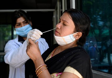 NoIDA INDIA 8 Nisan 2023 Bir sağlık çalışanı, Noida Hindistan 'da 8 Nisan 2023 tarihinde 30. Bölge Hastanesi' ndeki Covid 19 testi için örnek topluyor. Verilere göre Hindistan 'da son 24 saat içinde aktif Covid 19 vakasında keskin bir artış görüldü. 