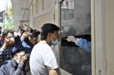 NEW DELHI INDIA APRIL 10 2023 A healthcare worker takes a swab sample of a man during a mock drill to check COVID 19 preparedness amid rising cases of coronavirus at RML Hospitalon April 10 2023 in New Delhi India India began a two day nationwide dri clipart