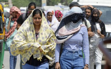 GURUGRAM INDIA 13 Nisan 2023 'te Parveen Kumar Hindustan Times tarafından Gurugram Hindistan' da 13 Nisan 2023 'te otobüs durağı yakınlarındaki eski Delhi yolunda görüldüğü gibi güneşten kaçmak için başlarını bir bezle örttükleri görüldü.