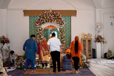 NOIDA INDIA APRIL 14 2023 Devotees offering prayers at a Gurudwara at Sector 18 on the occasion of Baisakhi on April 14 2023 in Noida India Baisakhi also known as Vaisakhi is an important and popular harvest festival celebrated in the northern Indian clipart