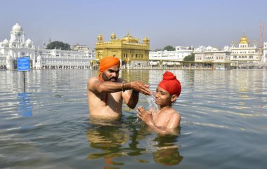 AMRITSAR INDIA 14 Nisan 2023 Takipçileri, 14 Nisan 2023 'te, Vaisakhi olarak da bilinen, Hindistan' ın Amritsar şehrinde, Baisakhi 'de düzenlenen ve önemli ve popüler bir hasat festivali olan Baisakhi' de kutsal sarovar su tankında yıkanır. 