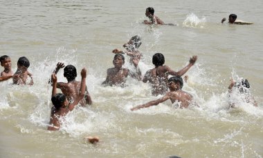 NEW DELHI INDIA 15 Nisan 2023 Çocuklar 15 Nisan 2023 tarihinde Yeni Delhi Indi 'de en yüksek sıcaklığın 40 dereceye ulaştığı Kuzey Hindistan' da sıcak hava dalgası koşullarının hakim olduğu su göletinin içinde keyfini çıkarıyorlar.