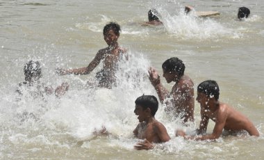NEW DELHI INDIA 15 Nisan 2023 Çocuklar 15 Nisan 2023 tarihinde Yeni Delhi Indi 'de en yüksek sıcaklığın 40 dereceye ulaştığı Kuzey Hindistan' da sıcak hava dalgası koşullarının hakim olduğu su göletinin içinde keyfini çıkarıyorlar.