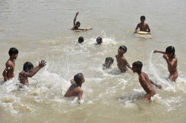 NEW DELHI INDIA 15 Nisan 2023 Çocuklar 15 Nisan 2023 tarihinde Yeni Delhi Indi 'de en yüksek sıcaklığın 40 dereceye ulaştığı Kuzey Hindistan' da sıcak hava dalgası koşullarının hakim olduğu su göletinin içinde keyfini çıkarıyorlar.