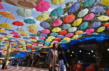 NEW DELHI INDIA Nisan 18 2023 Ziyaretçiler Şemsiye çatısı altında yürür Dilli Haat 'ta 18 Nisan 2023 Yeni Delhi Hindistan' da yükselen ısı biraz rahatlama verir 40 derece 40 derece Celsius dört derece yüksek kaydetti
