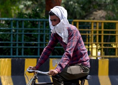 NoIDA INDIA Nisan 18 2023 Kafası havluya sarılı görülen onları korumak için sektör 38 Nisan 2023 Noida Hindistan 'da şiddetli sıcak hava dalgası En yüksek sıcaklık kaydetti 40 derece Celsius Normalden dört derece daha yüksek