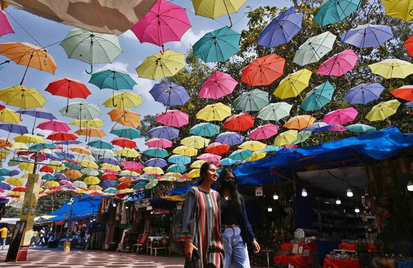 NEW DELHI INDIA APRIL 18 2023 Visitors walks under the Umbrella Roof at Dilli Haat which give some relief from rising temperature on April 18 2023 in New Delhi India Delhi registered a maximum temperature of 40 4 degrees Celsius four notches higher t