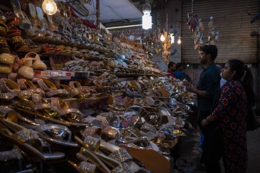 MUMBAI INDIA NİSAN 20 Nisan 2023 Müslüman kadın, 20 Nisan 2023 'te Hindistan' da Modh Ali Rd 'de yapılacak olan Müslüman bayram alışverişi kapsamında bir tezgahtaki ayakkabılara bakıyor. 