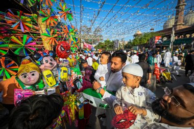 NEW DELHI INDIA APRIL 22 2023 Children buy colourful balloons after offering Eid al Fitr prayer marking the end of the holy fasting month of Ramadan with their families at the Jama Masjid on April 22 2023 in New Delhi India Muslims around the world  clipart