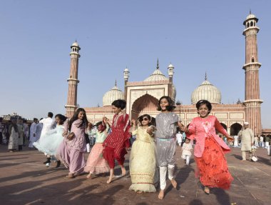 NEW DELHI INDIA: APRIL 22, 2023 - Children enjoying after offering prayers on the occasion of Eid ul Fitr at Jama Masjid in Old Delhi on April 22 2023 in New Delhi India Muslims around the world are getting into the festive Eid spirit.  clipart