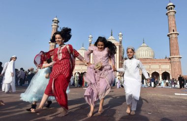 NEW DELHI INDIA: APRIL 22, 2023 - Children enjoying after offering prayers on the occasion of Eid ul Fitr at Jama Masjid in Old Delhi on April 22 2023 in New Delhi India Muslims around the world are getting into the festive Eid spirit.  clipart