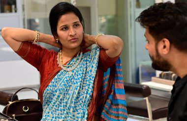 Hyderbad 'dan 22 Nisan 2023' te MUMBAI INDIA Shilpa Jain, eşi Rajesh Jain 'e, 22 Nisan 2023' te Kalbhadevi 'deki Umedmal Trilokchand Zaveri Mücevherleri' nden Akshay Tritiya vesilesiyle altın mücevher alırken kolye gösteriyor. 