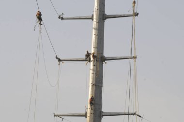 GURUGRAM INDIA APRIL 23 2023 Dakshin Haryana Bijli Vitran Nigam DHBVN workers seen changing the High Tension wires before the summer season on a newly installed high tension electric pole at sector 15 near Roseland Park on April 23 2023 in Gurugram I clipart