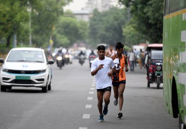 NOIDA INDIA APRIL 24 2023 Sansad Khel Spardha 2023 Maraton koşucuları 24 Nisan 2023 tarihinde Noida Hindistan 'da 21A sektöründe barikat kurmadan trafikte koşarken görüldü.